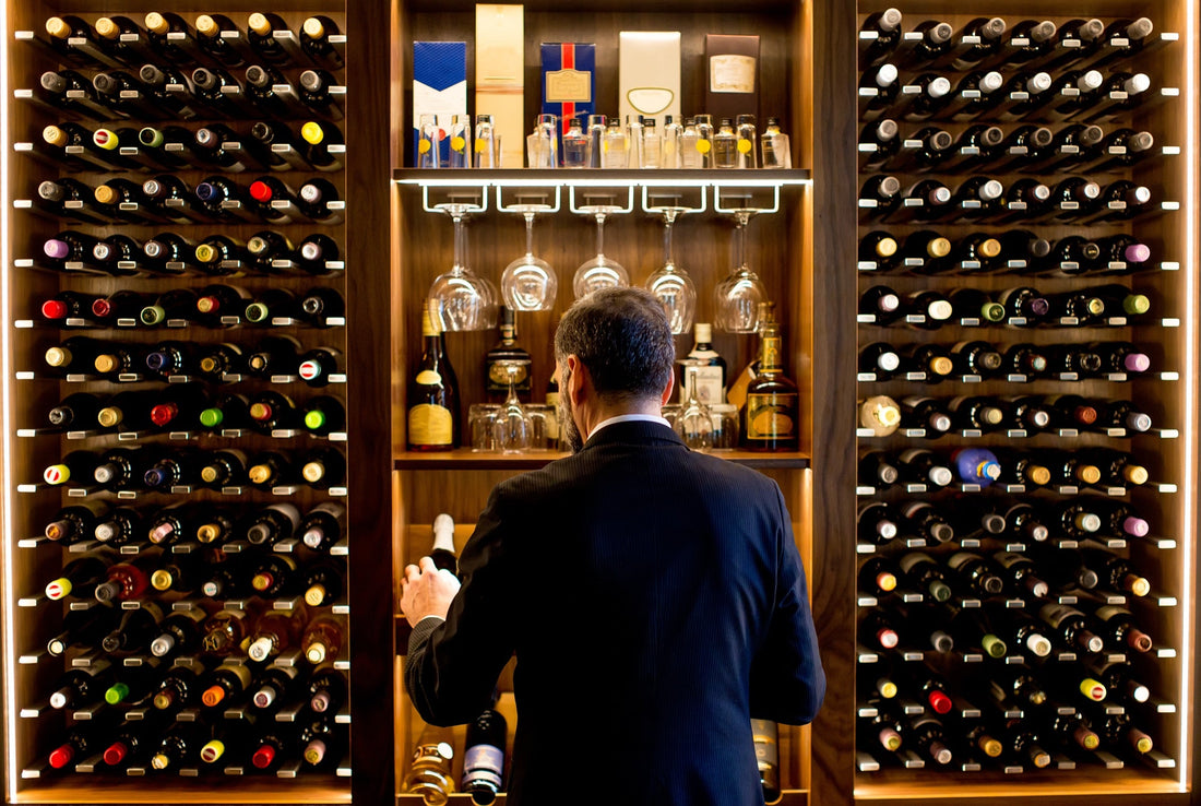 Persona eligiendo una botella de vino en tienda